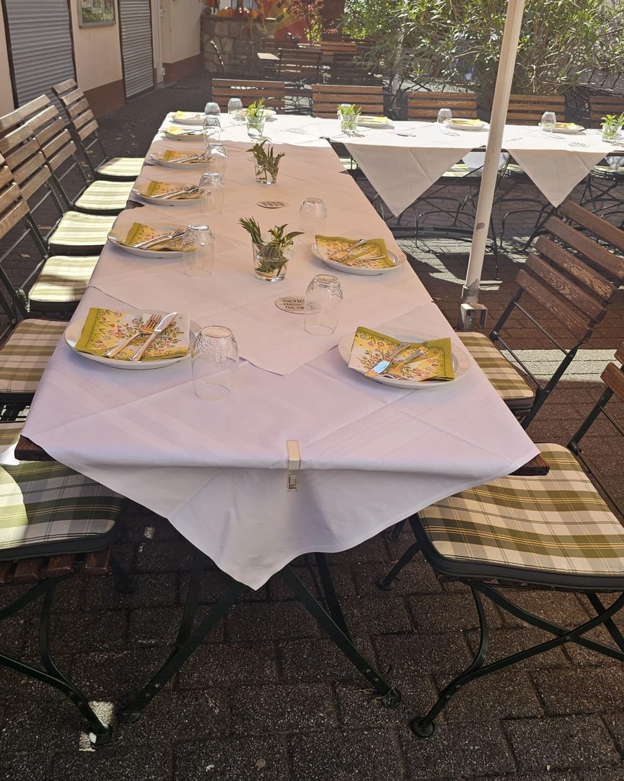 Lange, weiß eingedeckte Tafel im Biergarten