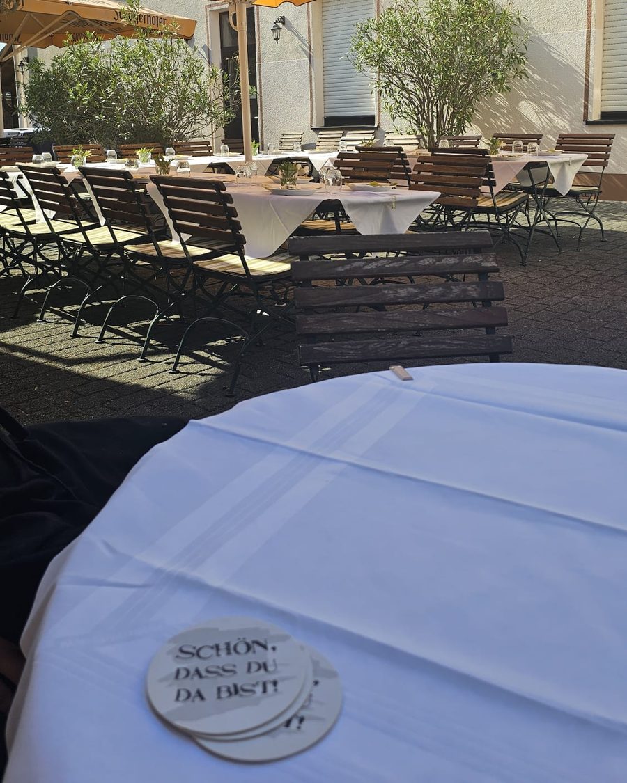 Biergarten mit Sonnenschirmen und eingedeckten Tischen